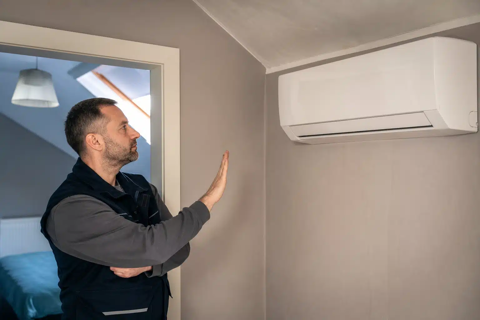 Homme vérifiant une climatisation murale